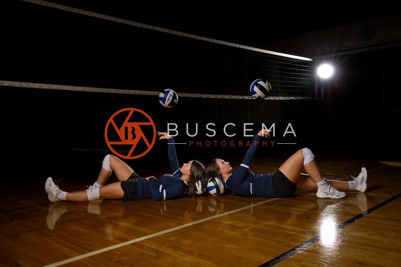 Two Coeur du Christ Academy volleyball players posed on the court beneath the net