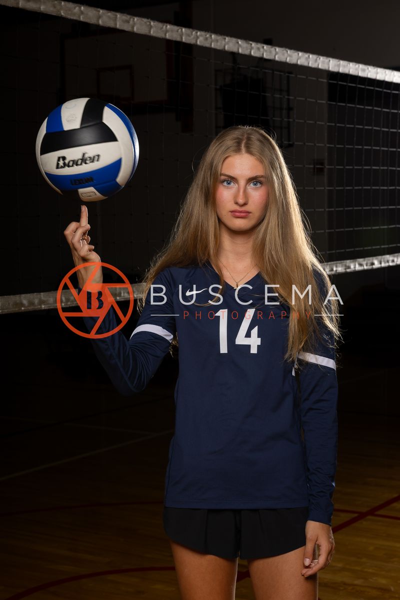 Coeur du Christ Academy volleyball player in a number 14 jersey balancing a volleyball