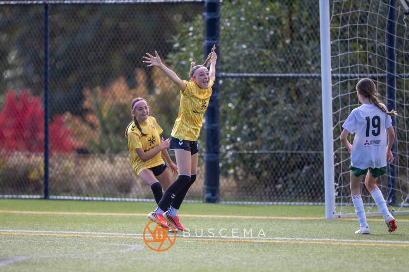 Sting 13G Academy player celebrating with her arms raised near the goal