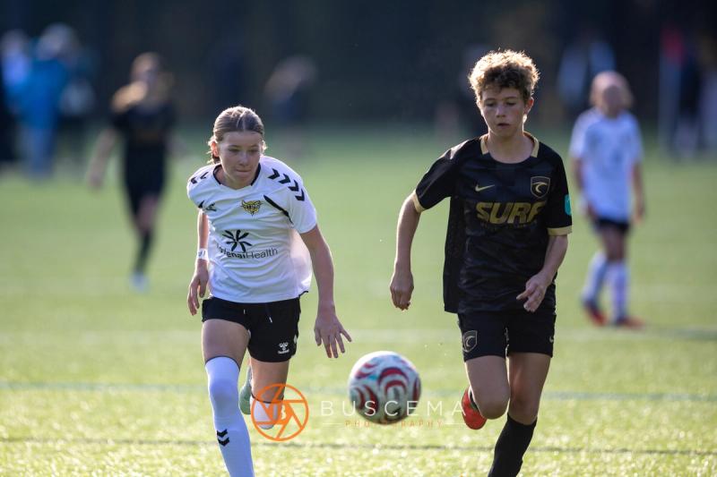 Sting 13G Academy player racing a Western WA Surf player to the ball