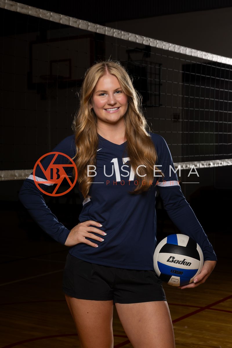Coeur du Christ Academy volleyball player holding a volleyball in the Saints gym
