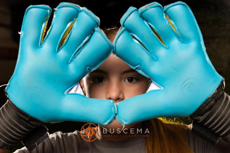 Sting 13G Academy goalkeeper framing her face with her gloves