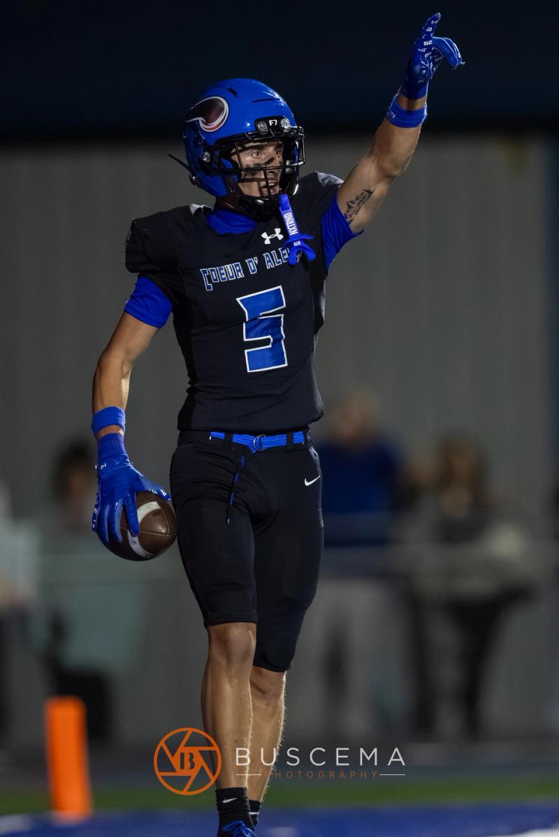 A Coeur d'Alene player raises an arm holding the ball after a score