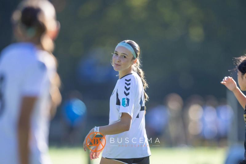 Sting 13G Academy player looking back over her shoulder and smiling