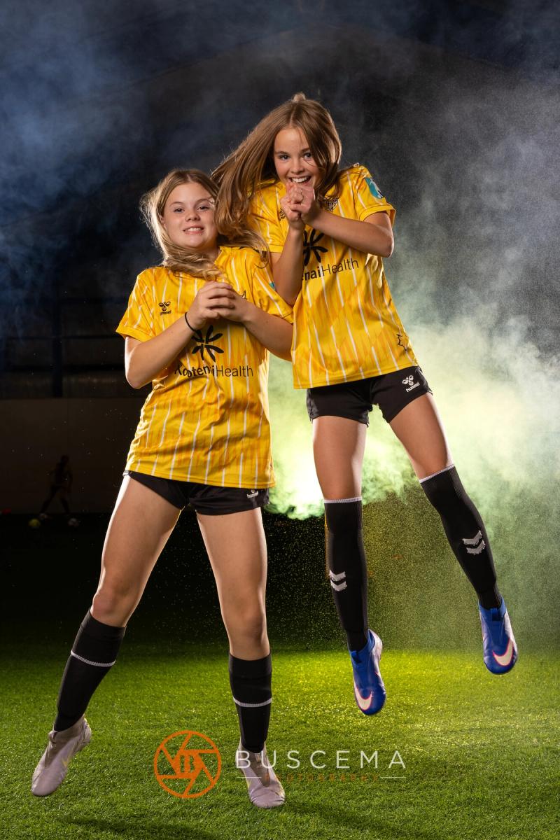Two Sting 13G Academy players jumping together in the smoke