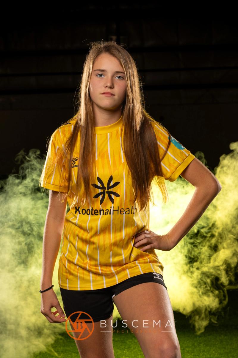 Sting 13G Academy player with her hands on her hips in the smoke