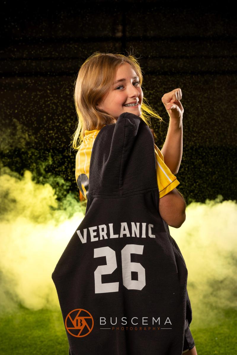 Sting 13G Academy player smiling over her shoulder holding her number 26 jersey