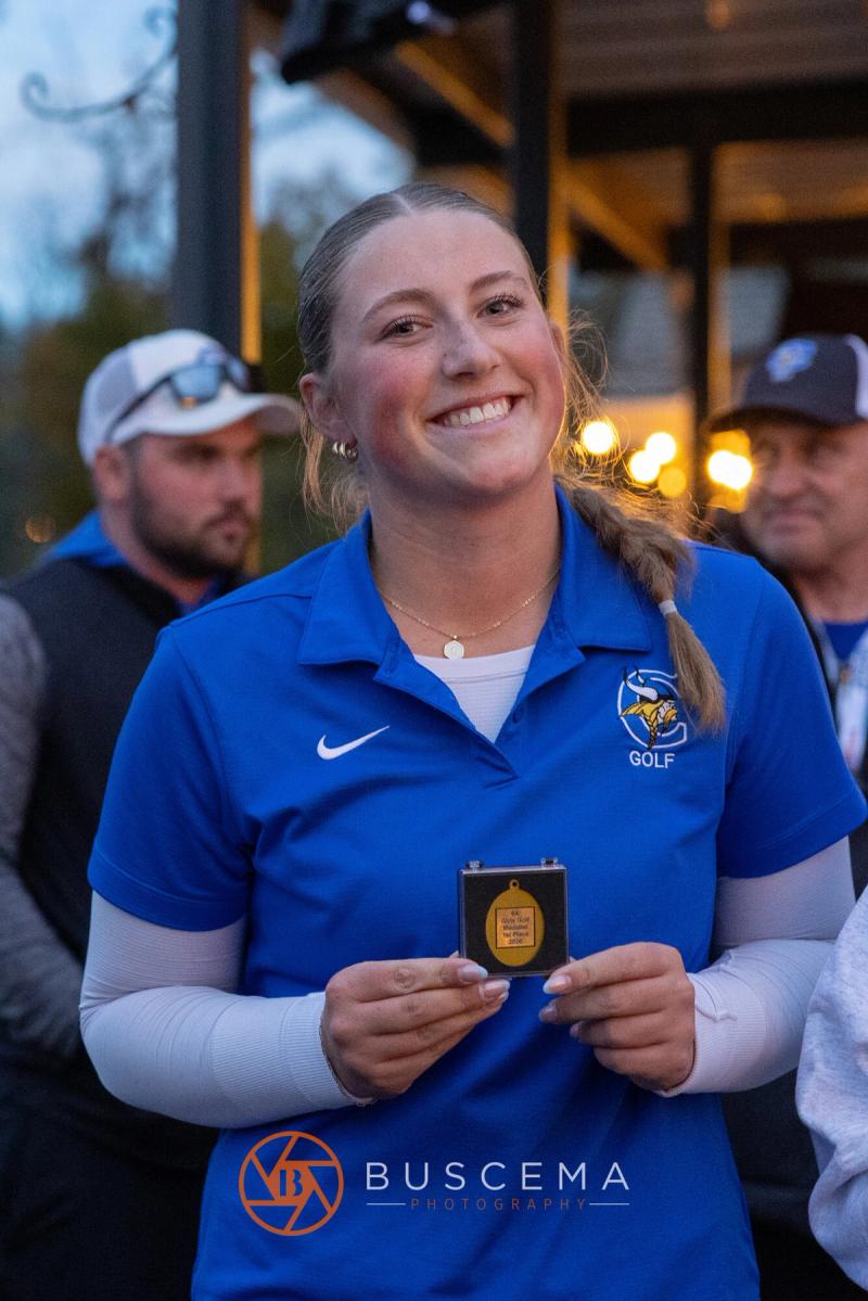 Coeur d'Alene girls golfer holding up her state medal at the 6A state golf championships at Avondale Golf Club