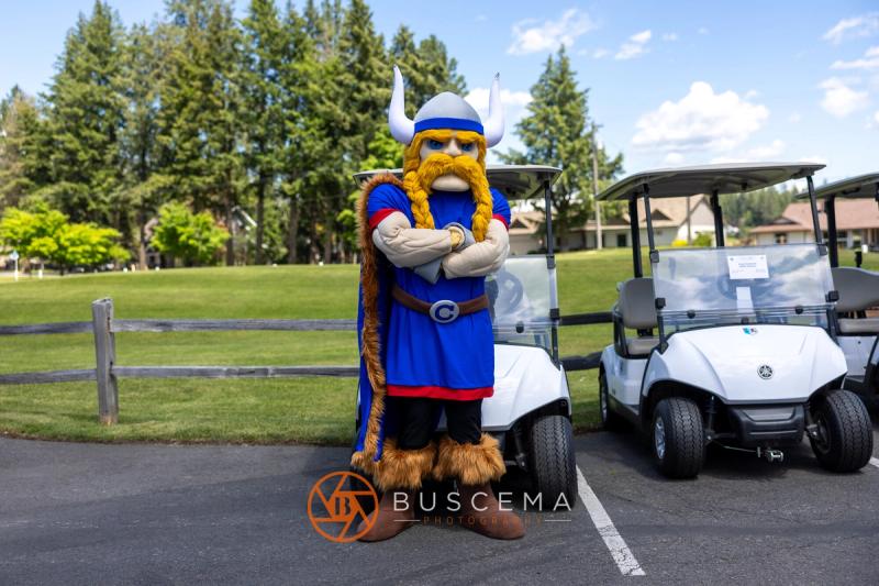 The Viking mascot standing with arms crossed beside the cart line