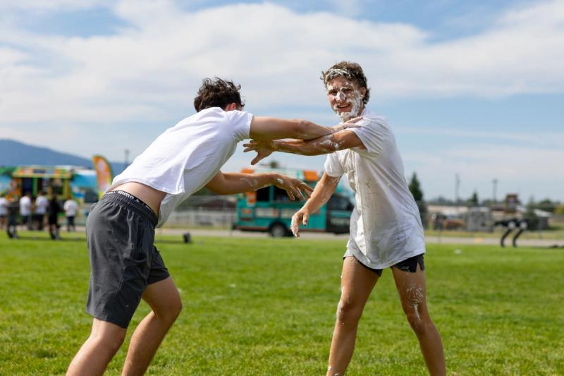 Coeur d'Alene seniors wrestling in the grass during the shaving cream fight