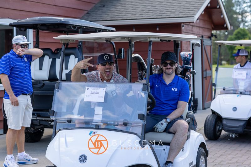 Golfers in a cart laughing and posing before heading out