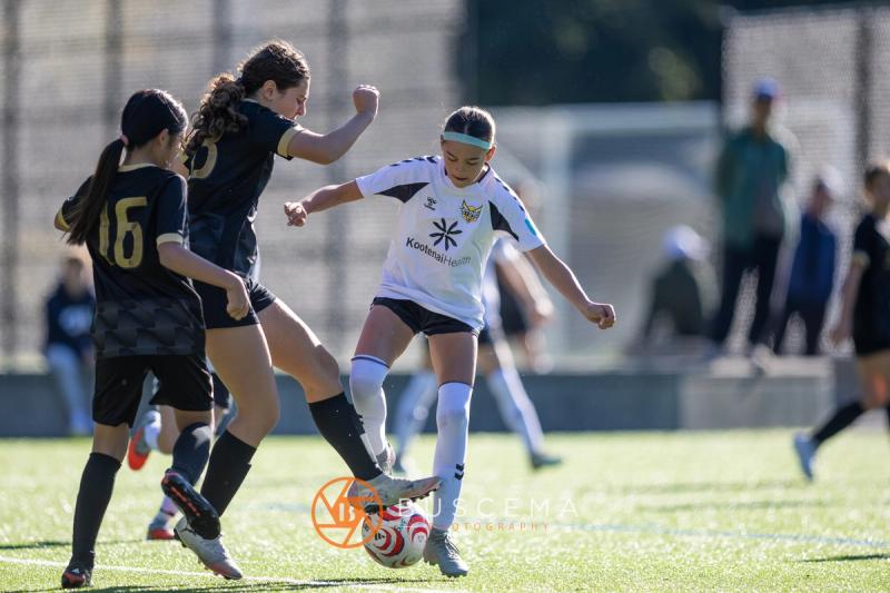 Sting 13G Academy player battling two Western WA Surf players for the ball