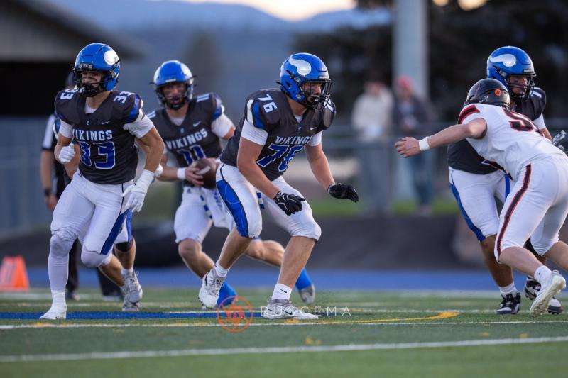 Coeur d'Alene backfield running a play as the offensive line pulls against Lewis and Clark