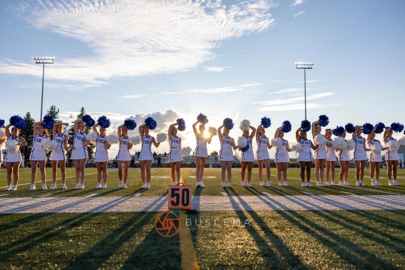 Coeur d'Alene cheer squad lined up across the fifty yard line at Viking Field in evening light