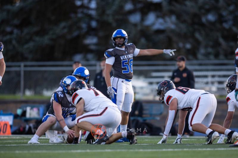 Coeur d'Alene number 58 pointing out the call at the line of scrimmage against Lewis and Clark