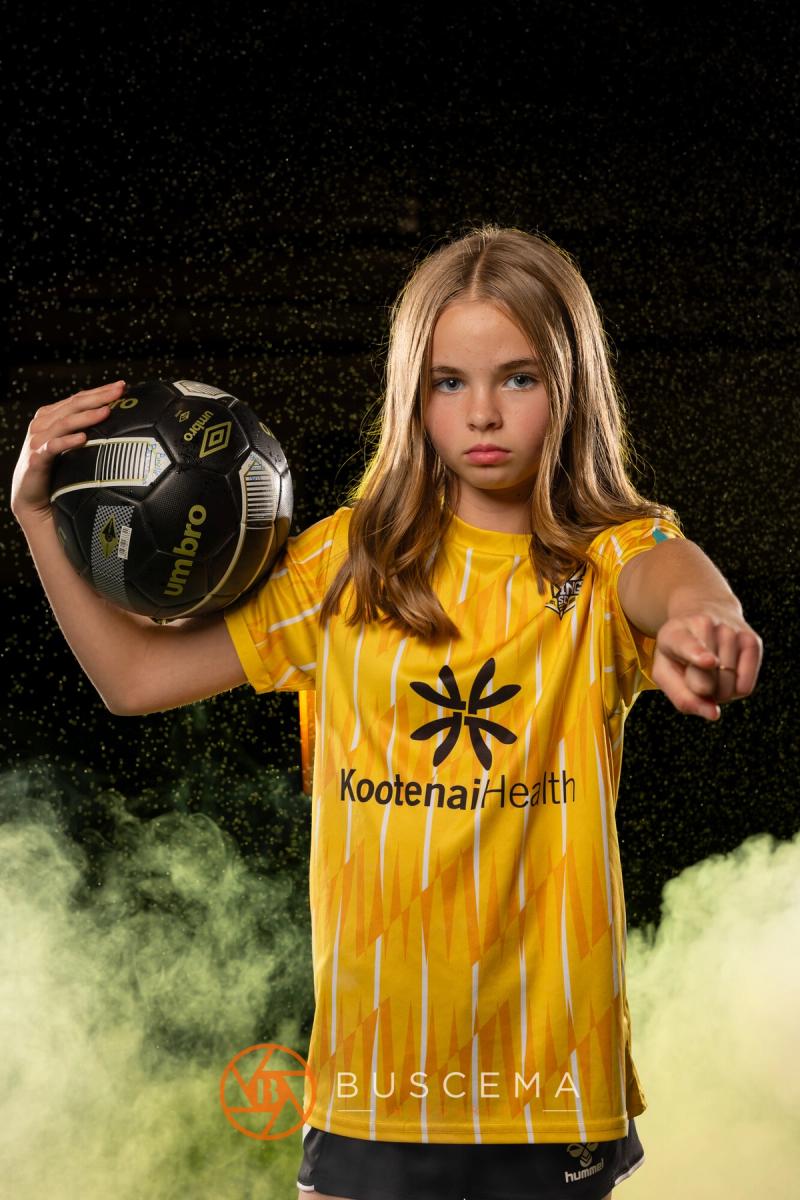 Sting 13G Academy player pointing at the camera with a ball on her shoulder