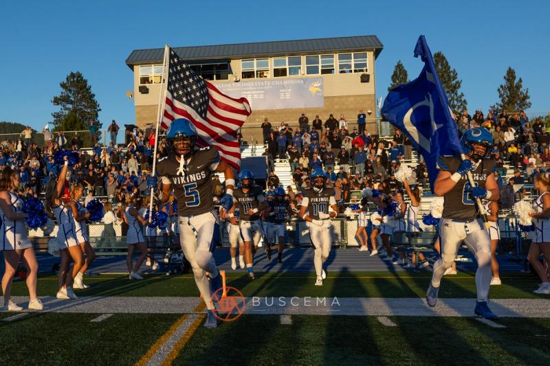 Coeur d'Alene Vikings take the field behind the American flag for the 2026 home opener
