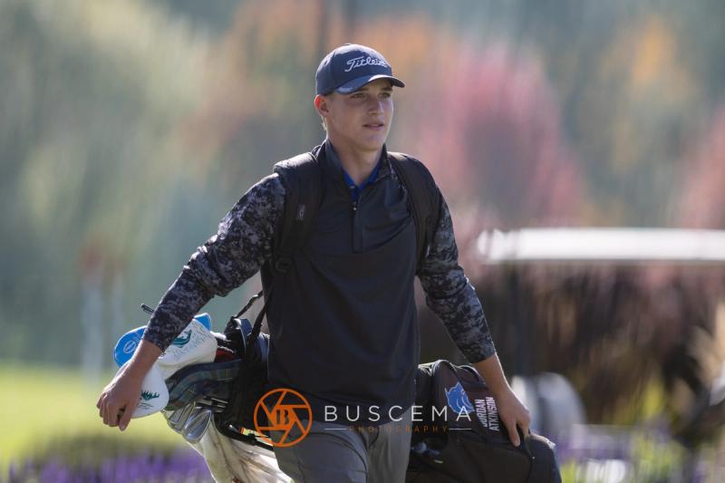 Smiling golfer walking down the fairway with his bag at the 6A state golf championships at Avondale Golf Club