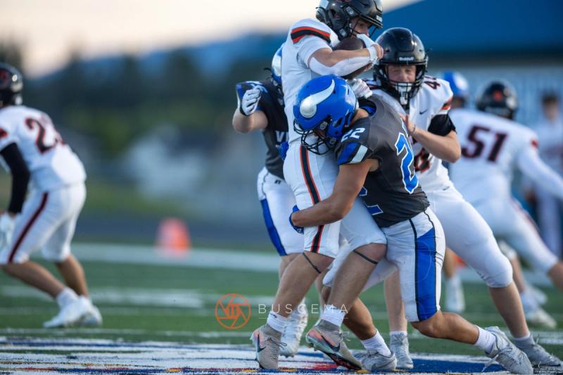 Coeur d'Alene defenders wrap up a Lewis and Clark ball carrier