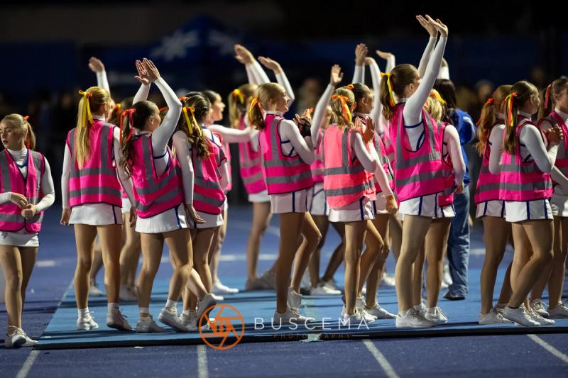 The Coeur d'Alene cheer squad with arms raised on the sideline in pink