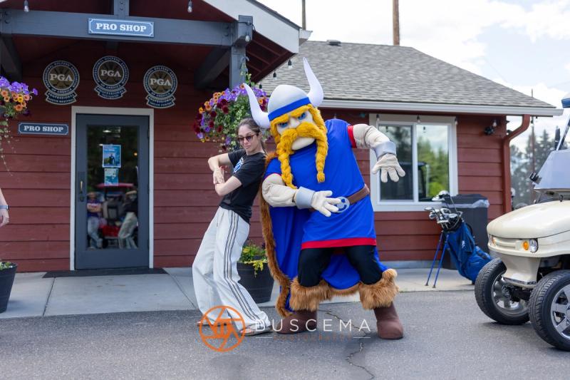 A golfer and the Viking mascot dancing outside the Avondale pro shop
