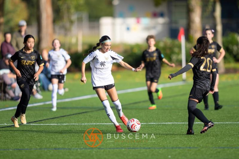 Sting 13G Academy player dribbling between Western WA Surf defenders