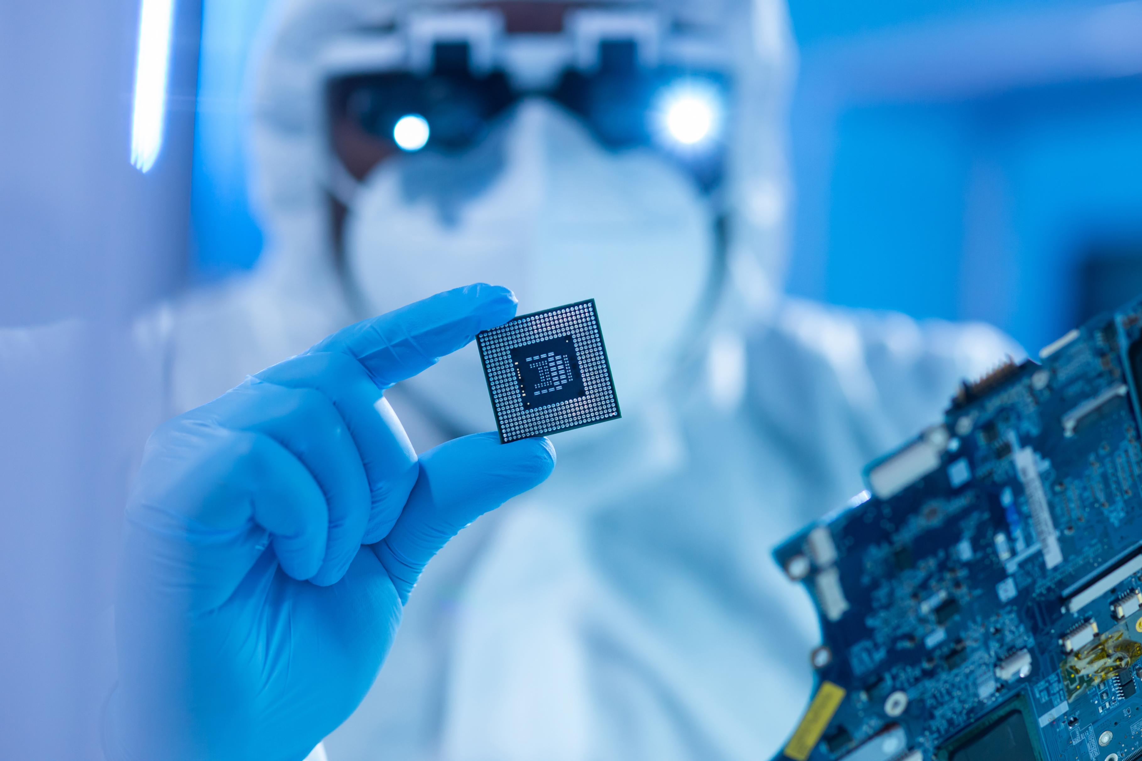 Engineer in cleanroom inspecting semiconductor