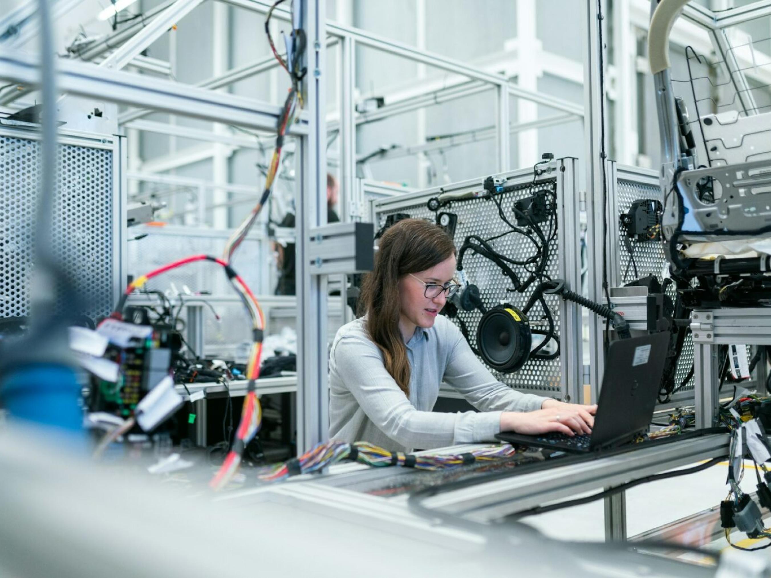 Process engineer with laptop on factory floor