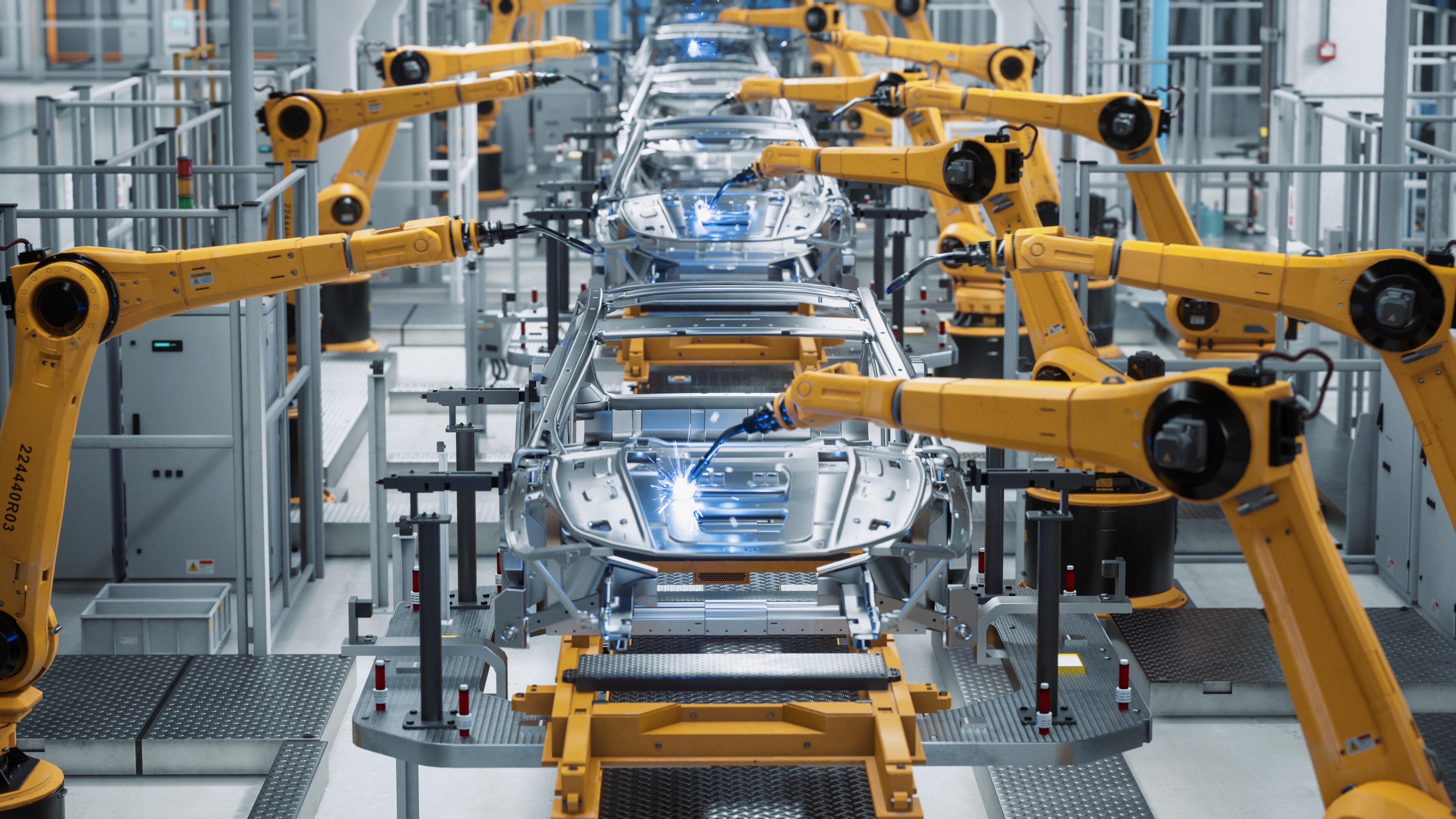 Automotive assembly line with industrial robotic arms welding the frames