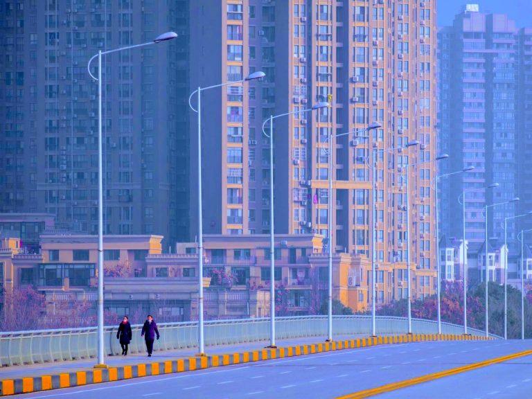 People wearing face masks walk down a deserted street in Wuhan in central China’s Hubei Province, Tuesday, Jan. 28, 2020. Arek Rataj / AP