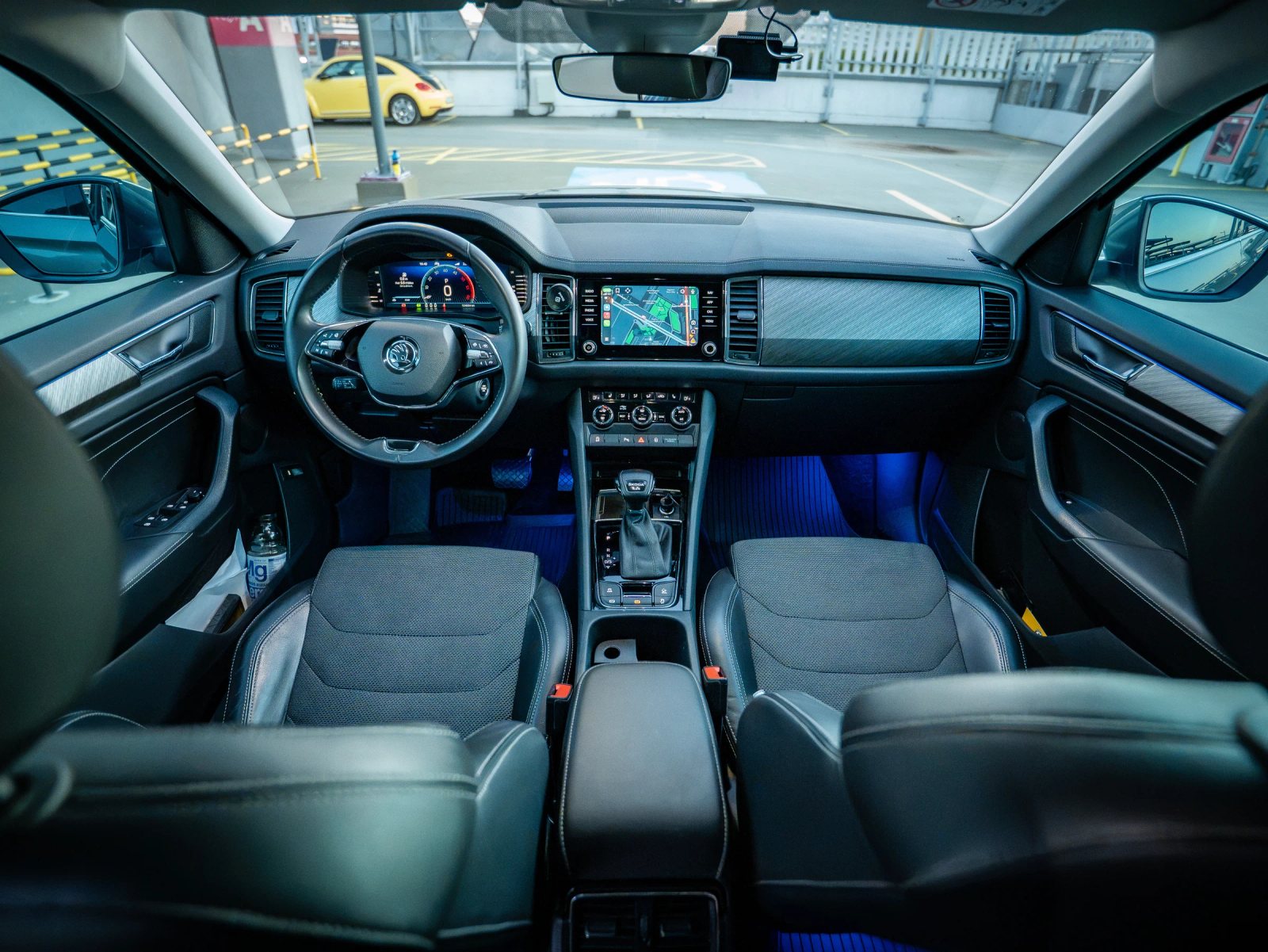 Škoda Kodiaq gri, vedere amplă a interiorului cu bordul și scaunele din față.