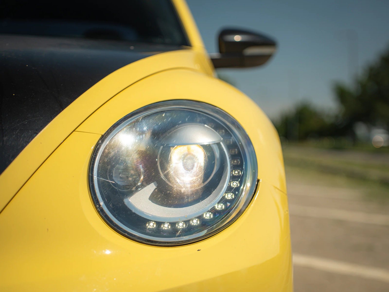 Volkswagen Beetle — prim-plan al farului și caroseriei.