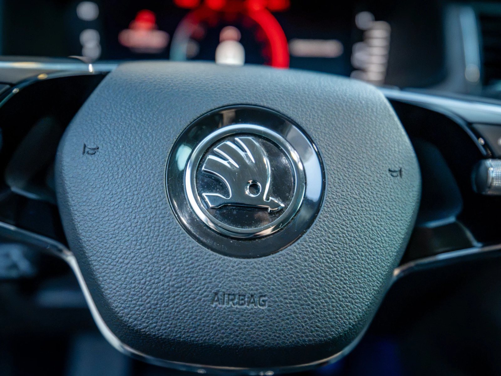 Škoda Kodiaq gri, detaliu interior al emblemei de pe volan.