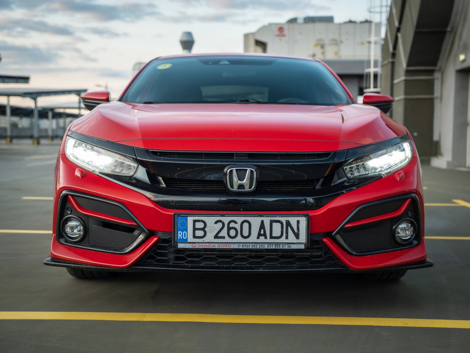 Honda Civic — vedere frontală în parcare.