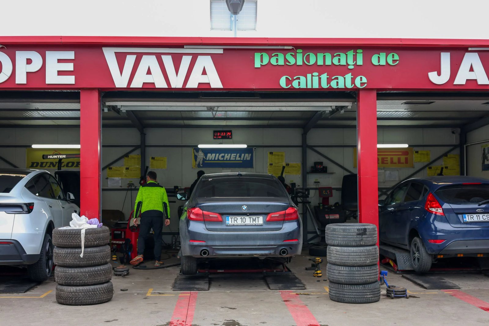 Fațada vulcanizării VAVA cu mașini în zona de service
