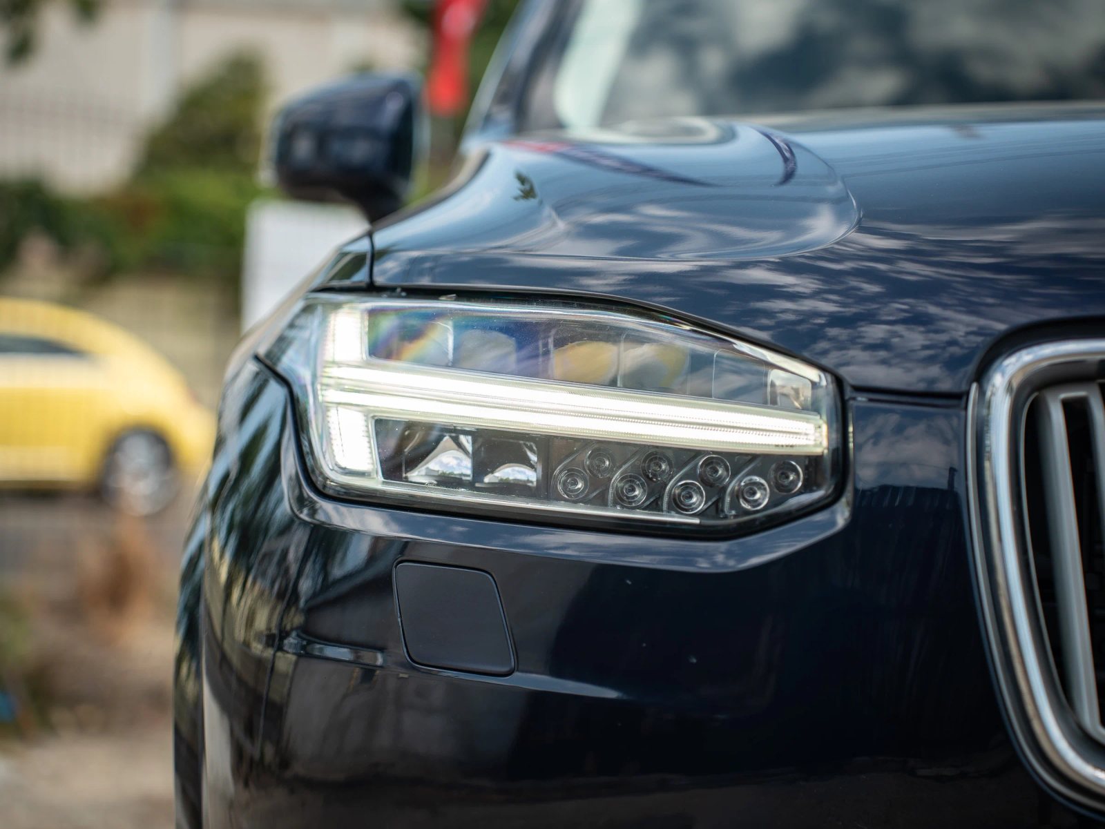 Volvo XC90 — prim-plan al farului și caroseriei.