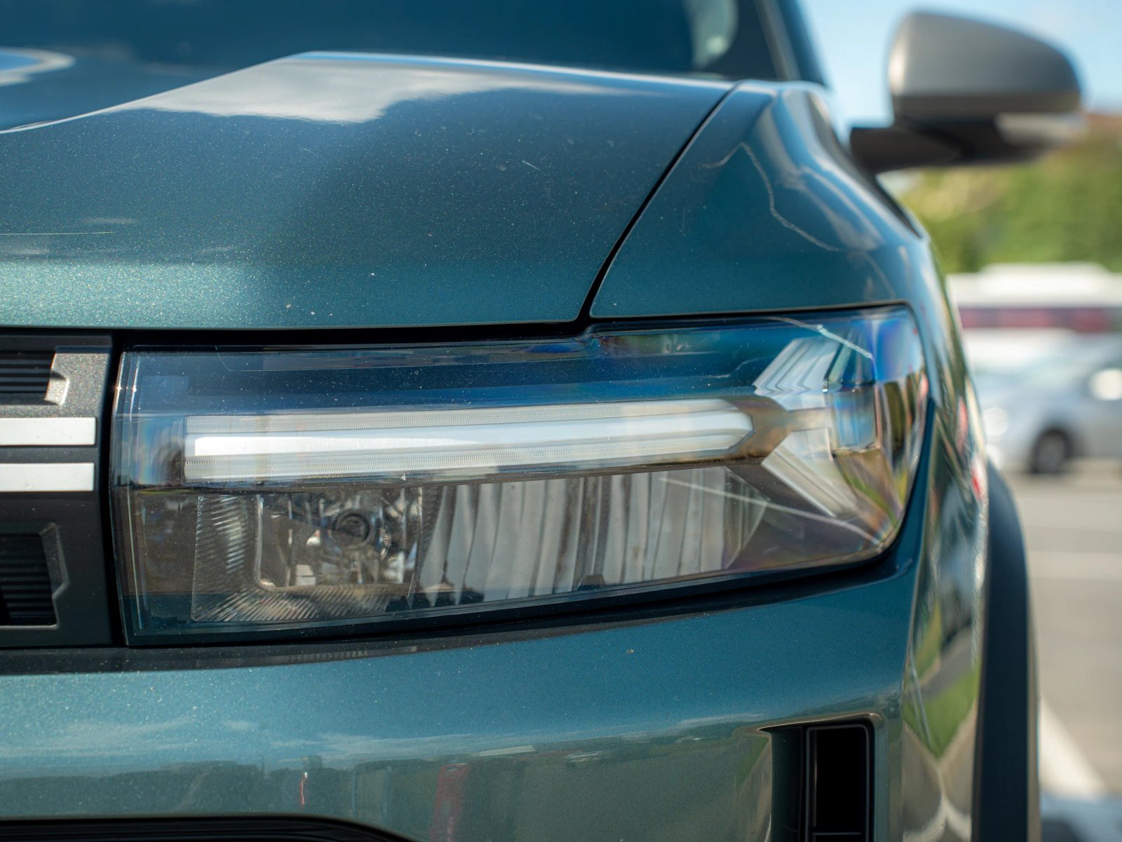 Dacia Duster — prim-plan al farului și caroseriei.