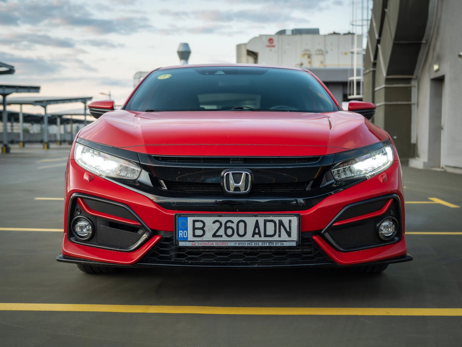 Honda Civic — vedere frontală în parcare.