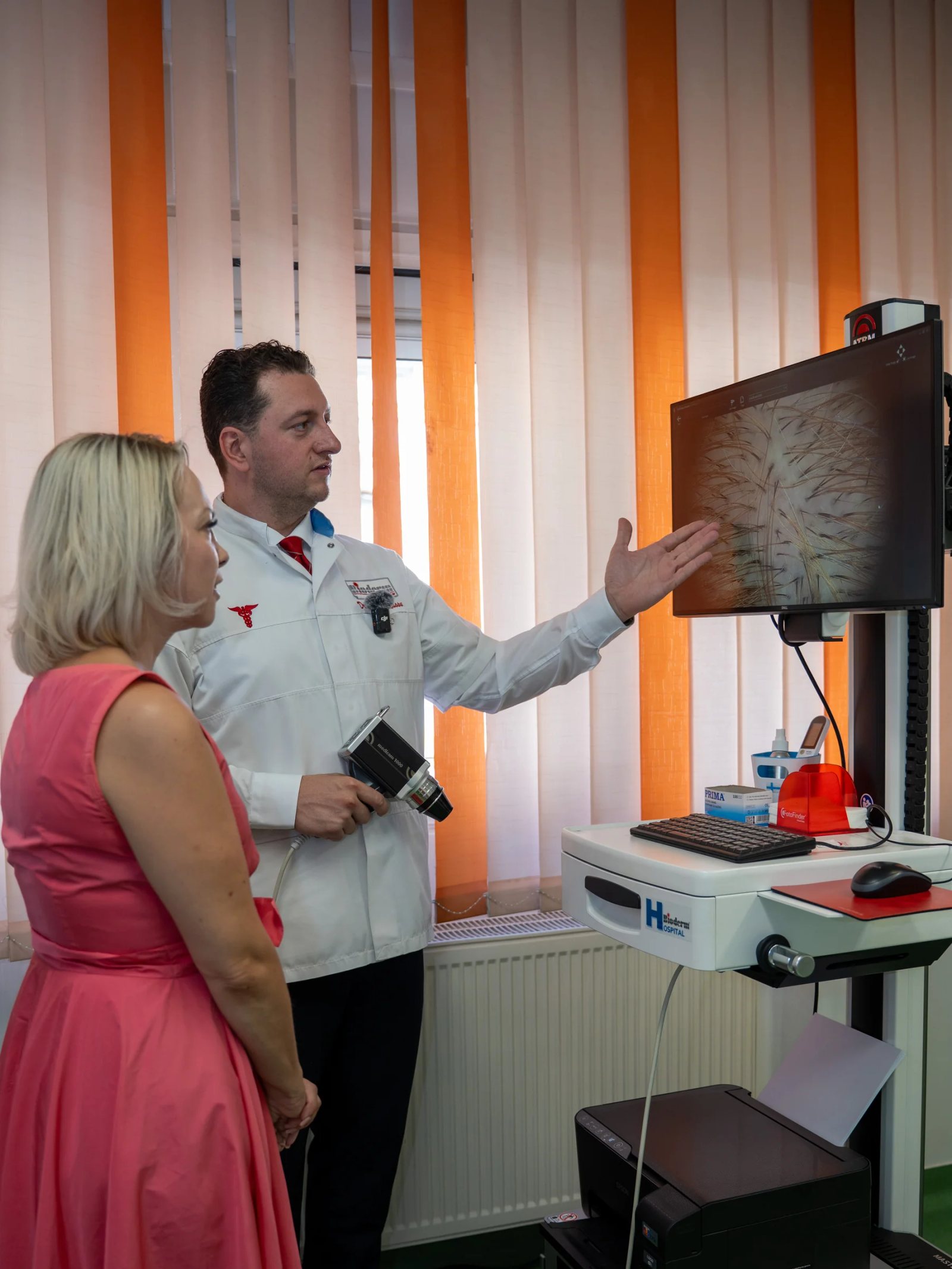 Specialistul prezintă pe monitor imagini ale scalpului unei vizitatoare