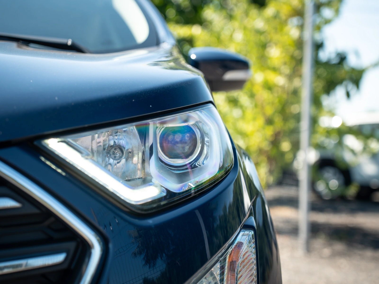 Ford EcoSport — prim-plan al farului și caroseriei.
