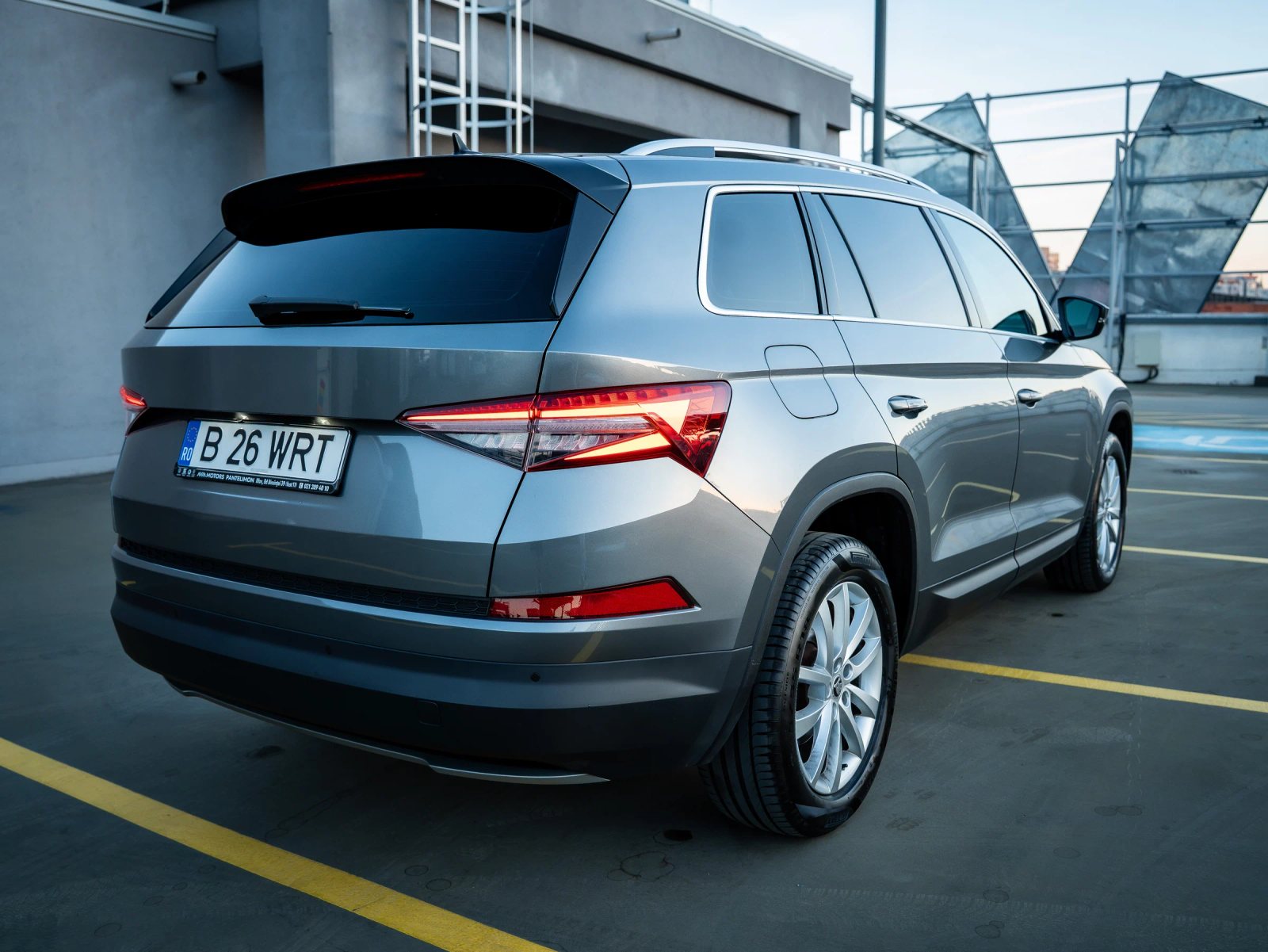 Škoda Kodiaq gri, cadru exterior din spate-dreapta cu hayonul, stopurile și roțile vizibile.