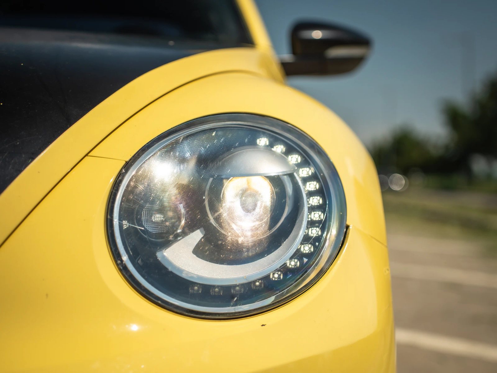 Volkswagen Beetle — prim-plan al farului și caroseriei.