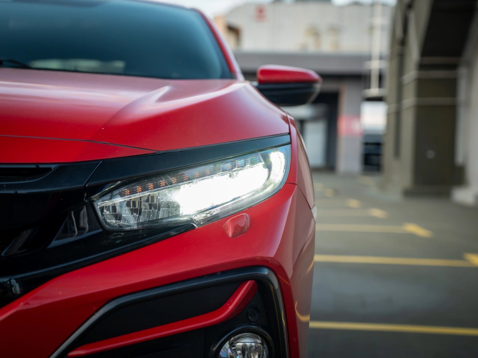 Honda Civic — prim-plan al farului și caroseriei.