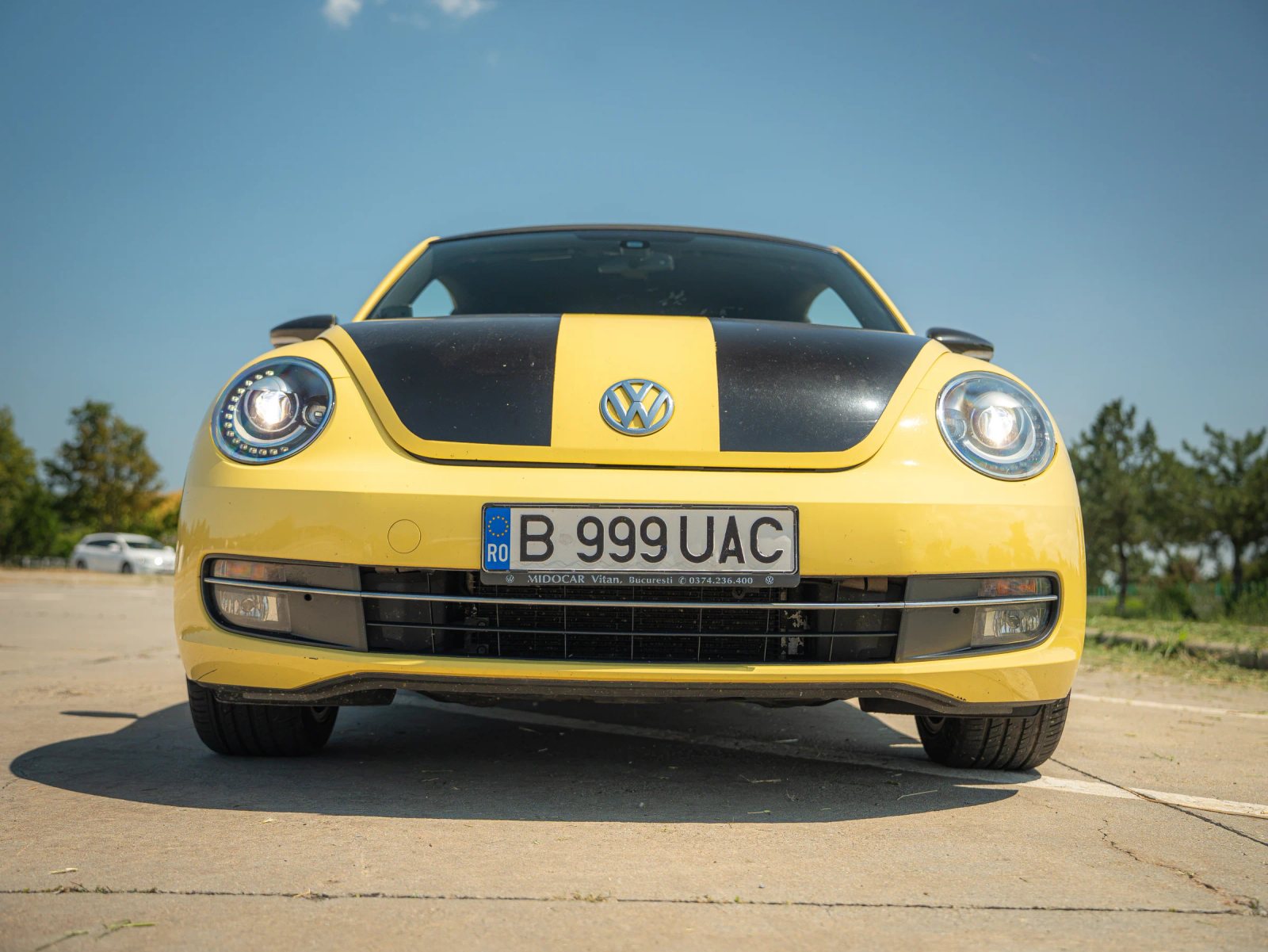 Volkswagen Beetle — vedere frontală în parcare.