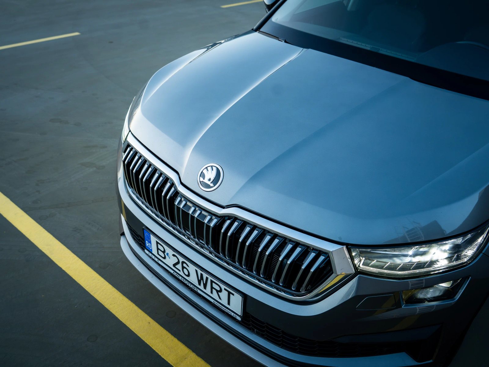 Škoda Kodiaq gri, cadru de sus concentrat pe capotă, emblemă și grila frontală.