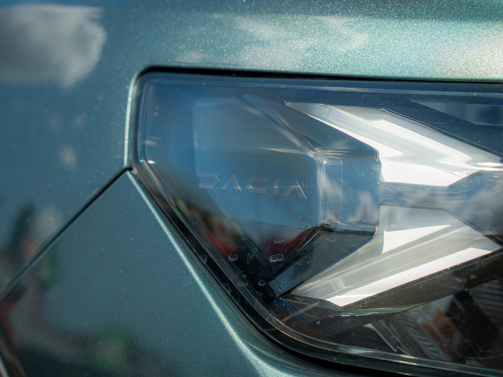 Dacia Duster — prim-plan al farului și caroseriei.