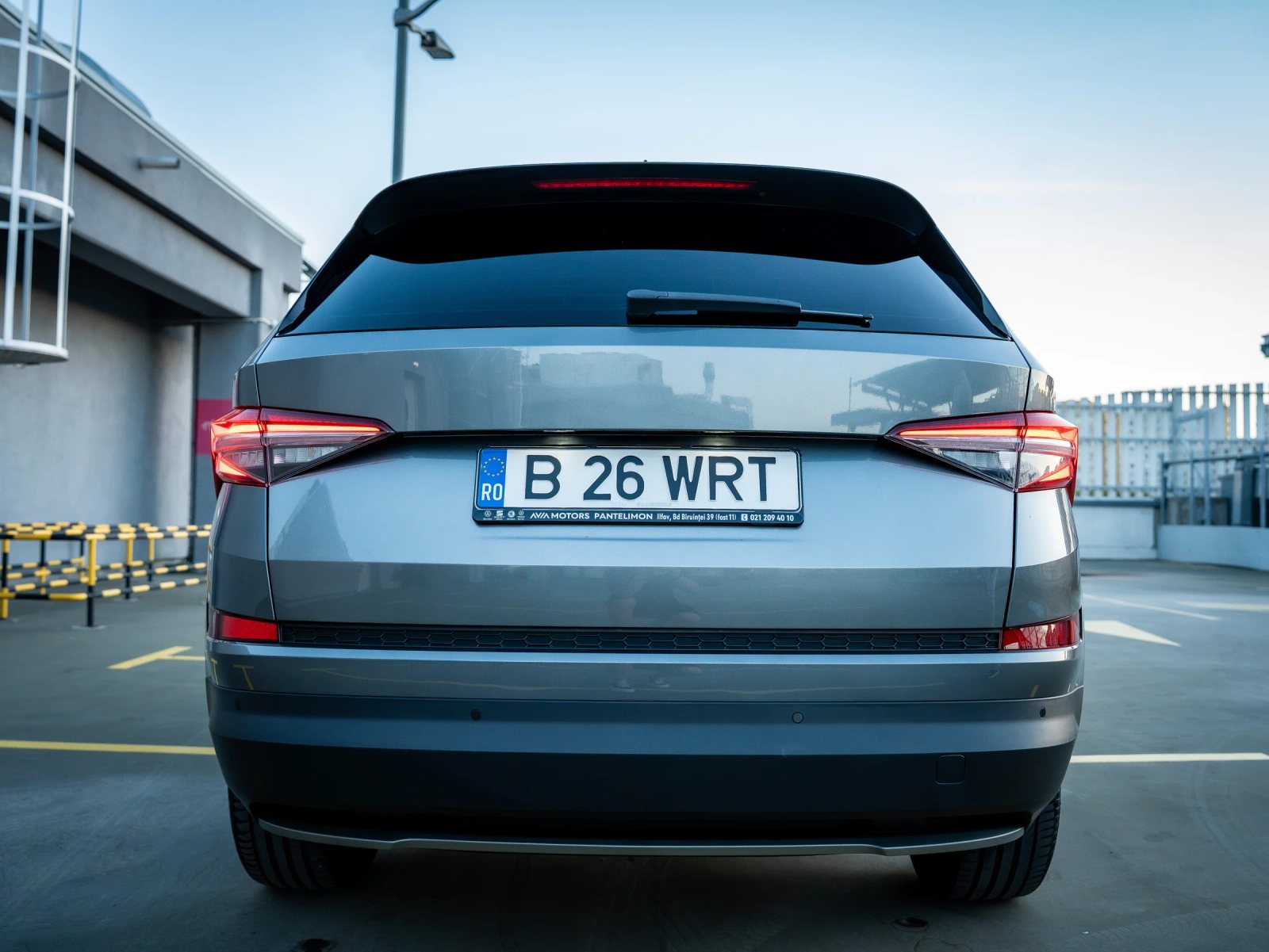 Škoda Kodiaq gri, vedere frontală din spate cu hayonul și stopurile centrate.