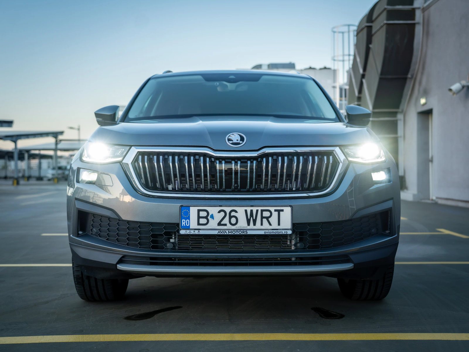 Škoda Kodiaq gri, vedere frontală de exterior cu grila și farurile încadrate simetric.