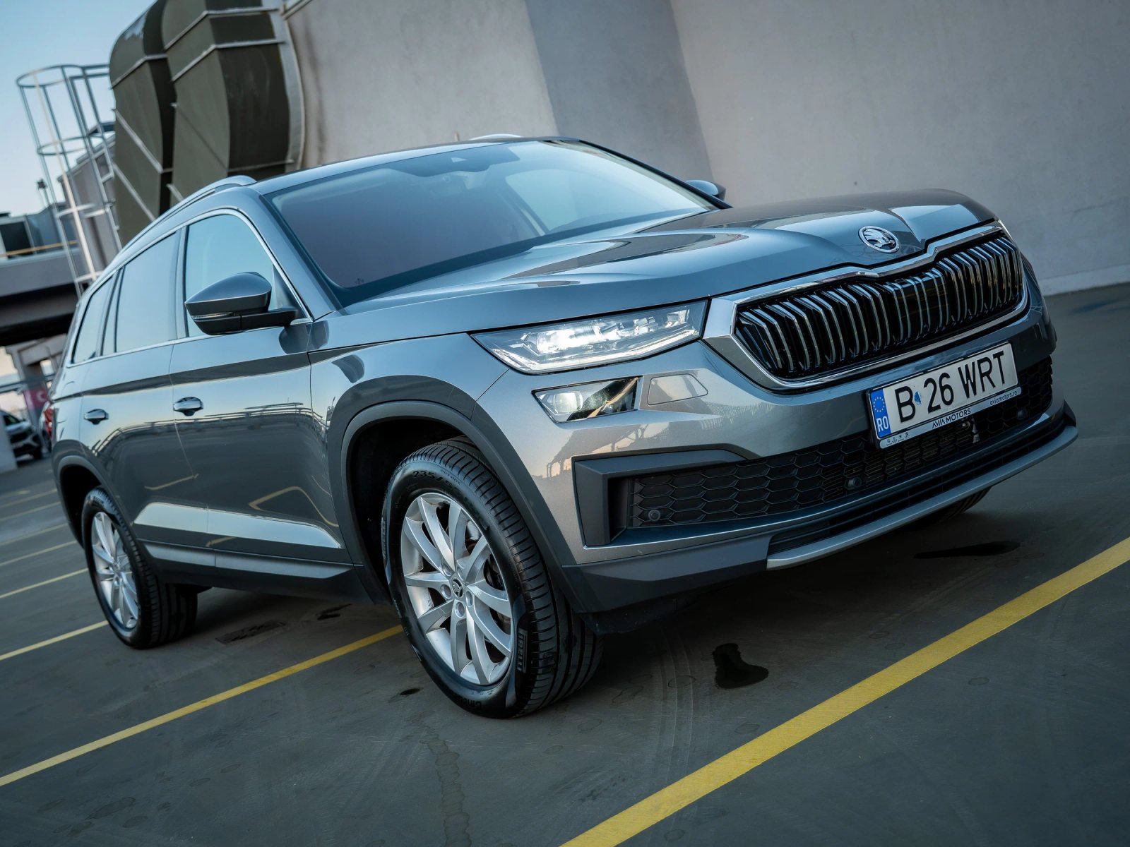 Škoda Kodiaq gri, cadru exterior înclinat din față-dreapta, cu întreaga mașină vizibilă.