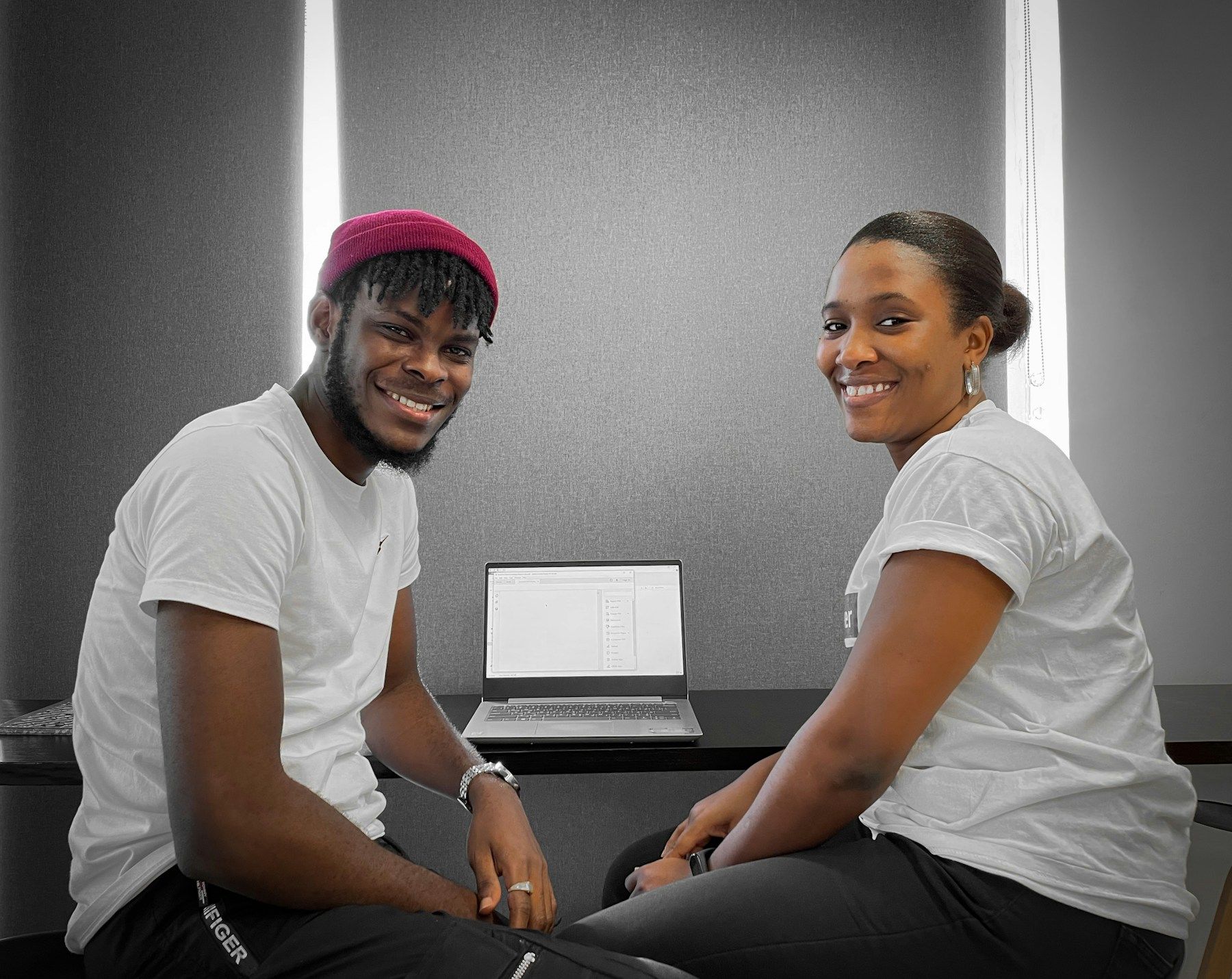Two young professionals working together on a laptop